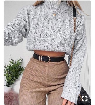 Trend da donna 2024 in modo formale: Combina un dolcevita lavorato a maglia grigio con pantaloni skinny di lana marrone chiaro per un look raffinato per il tempo libero.
