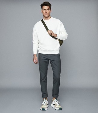 Look alla moda per uomo: Felpa bianca, Chino grigi, Scarpe sportive multicolori, Marsupio di tela verde oliva