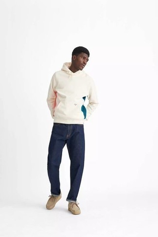 Look alla moda per uomo: Felpa con cappuccio stampata beige, Jeans blu scuro, Chukka in pelle scamosciata beige, Calzini bianchi