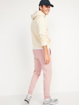 Come indossare e abbinare pantaloni sportivi rosa con scarpe sportive grigie per un uomo di 20 anni: Punta su una felpa con cappuccio beige e pantaloni sportivi rosa per un look comfy-casual. Scarpe sportive grigie sono una eccellente scelta per completare il look.