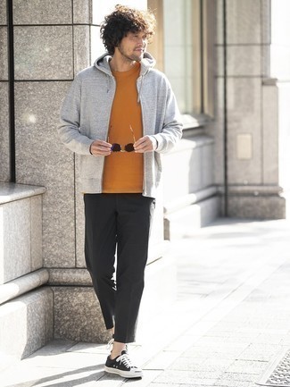 Look alla moda per uomo: Felpa con cappuccio grigia, T-shirt girocollo arancione, Chino neri, Sneakers basse di tela nere e bianche