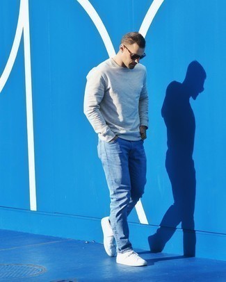 Look alla moda per uomo: Felpa grigia, Jeans azzurri, Sneakers basse di tela bianche, Occhiali da sole marrone scuro