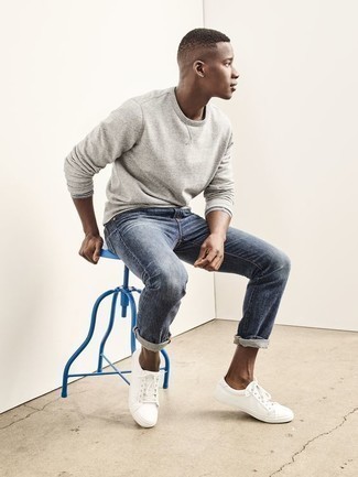 Come indossare e abbinare una felpa grigia con jeans blu: Indossa una felpa grigia con jeans blu per un look spensierato e alla moda. Sneakers basse in pelle bianche sono una splendida scelta per completare il look.