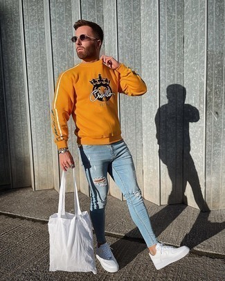 Come indossare e abbinare un maglione giallo quando fa caldo in modo rilassato: Prova ad abbinare un maglione giallo con jeans aderenti strappati azzurri per un'atmosfera casual-cool. Sfodera il gusto per le calzature di lusso e scegli un paio di sneakers basse in pelle bianche.