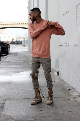Look alla moda per uomo: Felpa rosa, Jeans strappati grigi, Stivali casual in pelle scamosciata marroni