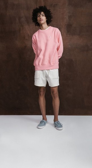 Come indossare e abbinare pantaloncini bianchi per un uomo di 20 anni quando fa caldo: Indossa una felpa rosa con pantaloncini bianchi per vestirti casual. Rifinisci questo look con un paio di sneakers basse di tela azzurre.