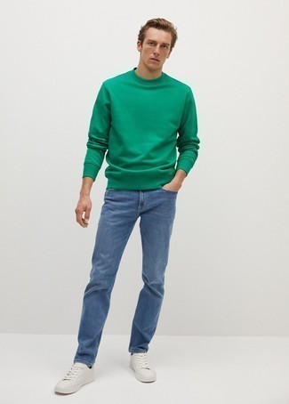 Come indossare e abbinare jeans blu: Scegli una felpa verde e jeans blu per un look semplice, da indossare ogni giorno. Perfeziona questo look con un paio di sneakers basse in pelle bianche.