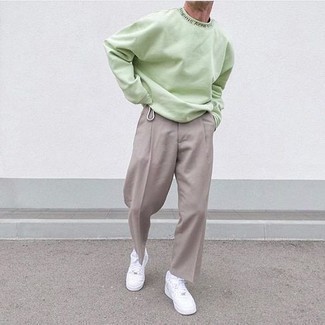 Come indossare e abbinare una felpa verde: Prova a combinare una felpa verde con chino grigi per un outfit comodo ma studiato con cura. Sneakers basse in pelle bianche sono una valida scelta per completare il look.