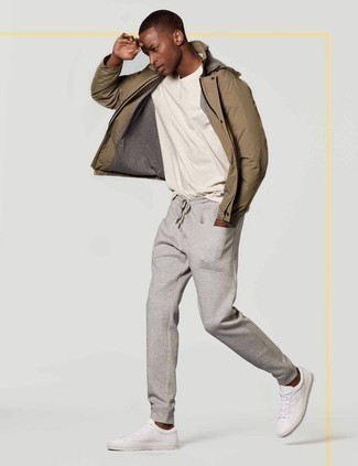 Look alla moda per uomo: Giacca a vento marrone chiaro, T-shirt girocollo bianca, Pantaloni sportivi grigi, Sneakers basse di tela bianche