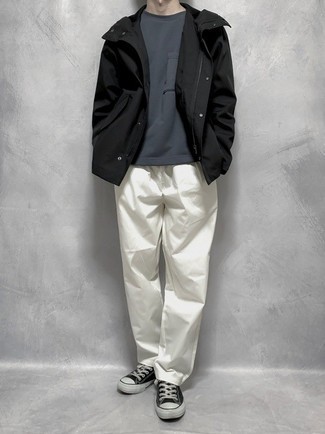 Look alla moda per uomo: Giacca a vento nera, T-shirt girocollo grigio scuro, Chino bianchi, Sneakers basse di tela nere e bianche