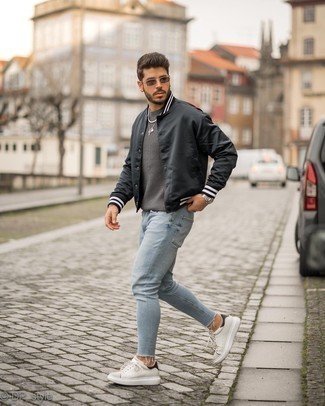 Quale sneakers basse indossare con una giacca college nera in modo casual: Abbina una giacca college nera con jeans aderenti azzurri per un look perfetto per il weekend. Mettiti un paio di sneakers basse per un tocco virile.