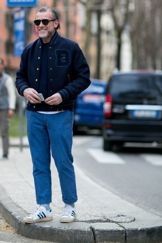 Come indossare e abbinare una giacca college blu per un uomo di 50 anni in modo casual: Opta per una giacca college blu e chino blu per un outfit comodo ma studiato con cura. Rifinisci questo look con un paio di sneakers basse in pelle bianche e blu scuro.