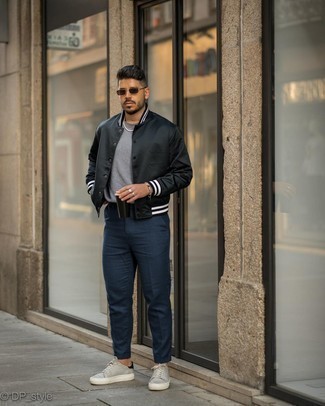 Come indossare e abbinare sneakers basse grigie per un uomo di 30 anni: Combina una giacca college nera con chino blu scuro per vestirti casual. Sneakers basse grigie sono una gradevolissima scelta per completare il look.