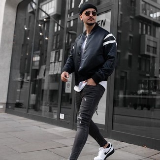 Come indossare e abbinare jeans grigi quando fa caldo in modo rilassato: Prova ad abbinare una giacca college nera con jeans grigi per una sensazione di semplicità e spensieratezza. Sneakers basse di tela bianche e nere sono una buona scelta per completare il look.
