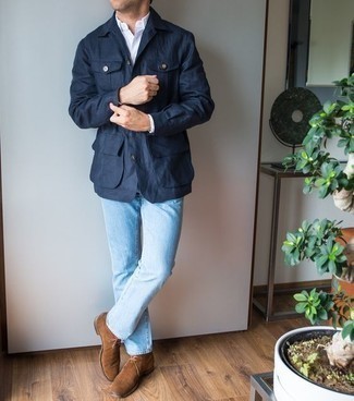 Come indossare e abbinare jeans azzurri con una camicia bianca in modo smart-casual: Potresti combinare una camicia bianca con jeans azzurri per un look trendy e alla mano. Sfodera il gusto per le calzature di lusso e prova con un paio di chukka in pelle scamosciata marroni.