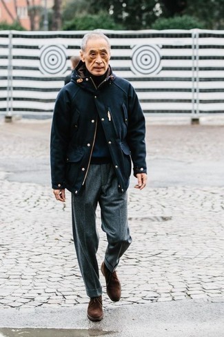 Moda uomo anni 60: Vestiti con una giacca da campo blu scuro e pantaloni eleganti di lana grigi per una silhouette classica e raffinata Chukka in pelle scamosciata marrone scuro renderanno il tuo look davvero alla moda.