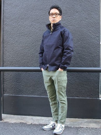 Look alla moda per uomo: Giacca da campo blu scuro, Pantaloni cargo verde menta, Scarpe sportive azzurre, Occhiali da sole trasparenti