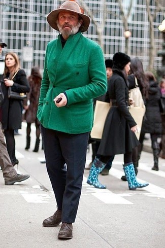 Un uomo che indossa un cappotto verde e occhiali da sole foto