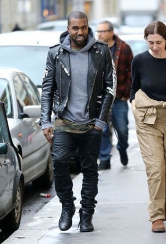Look di Kanye West: Giacca da moto in pelle nera, Felpa con cappuccio grigia, T-shirt girocollo mimetica verde oliva, Jeans neri