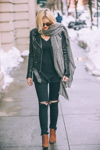 Look alla moda per donna: Giacca da moto in pelle nera, Maglione con scollo a v nero, Jeans aderenti strappati neri, Stivaletti in pelle terracotta