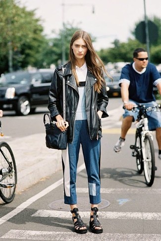 Look alla moda per donna: Giacca da moto in pelle nera, Polo bianco, Jeans patchwork blu, Sandali gladiatore in pelle neri