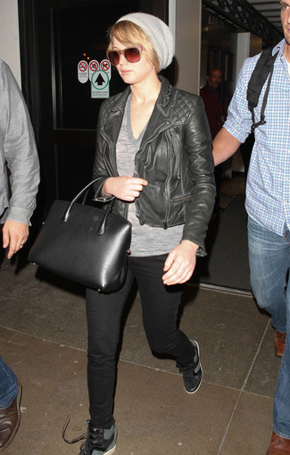 Look di Jennifer Lawrence: Giacca da moto in pelle trapuntata nera, T-shirt con scollo a v grigia, Jeans aderenti neri, Sneakers con zeppa in pelle nere