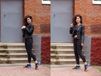 Look alla moda per donna: Giacca da moto in pelle nera, Top corto nero, Jeans aderenti neri, Scarpe sportive nere