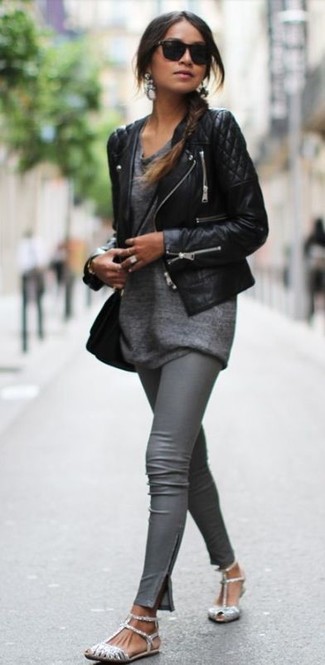 Look alla moda per donna: Giacca da moto in pelle trapuntata nera, Tunica grigia, Leggings in pelle grigi, Sandali piatti con paillettes argento