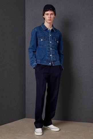 Quale giacca di jeans indossare con chino blu scuro in modo casual: Scegli una giacca di jeans e chino blu scuro per un look semplice, da indossare ogni giorno. Per distinguerti dagli altri, scegli un paio di sneakers basse di tela bianche.