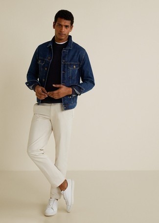Look alla moda per uomo: Giacca di jeans blu scuro, Maglione a trecce blu scuro, Chino bianchi, Sneakers basse in pelle bianche