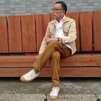 Come indossare e abbinare scarpe bianche per un uomo di 60 anni in modo casual: Prova a combinare una giacca di jeans beige con chino terracotta per vestirti casual. Per un look più rilassato, prova con un paio di sneakers basse di tela bianche.