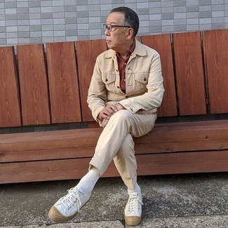 Come indossare e abbinare scarpe per un uomo di 60 anni quando fa caldo in modo smart-casual: Indossa una giacca di jeans beige con pantaloni eleganti beige per essere sofisticato e di classe. Per distinguerti dagli altri, scegli un paio di sneakers basse di tela bianche.