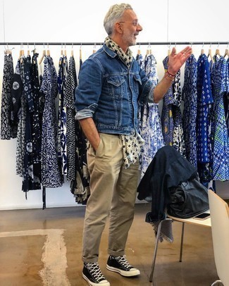 Moda uomo anni 50 in modo casual: Prova a combinare una giacca di jeans blu con chino beige per un look semplice, da indossare ogni giorno. Non vuoi calcare troppo la mano con le scarpe? Indossa un paio di sneakers alte di tela stampate nere e bianche per la giornata.