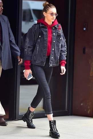 Look di Gigi Hadid: Giacca di jeans nera, Felpa con cappuccio rossa, Jeans aderenti neri, Stivali piatti stringati in pelle neri