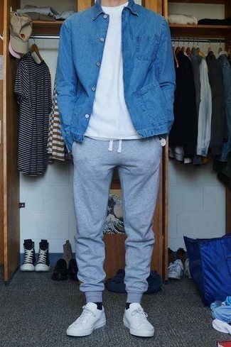Come indossare e abbinare una giacca di jeans blu scuro con sneakers basse in pelle bianche: Abbina una giacca di jeans blu scuro con pantaloni sportivi grigi per un look semplice, da indossare ogni giorno. Questo outfit si abbina perfettamente a un paio di sneakers basse in pelle bianche.