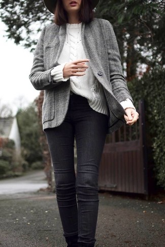Look alla moda per donna: Giacca di tweed grigia, Maglione a trecce bianco, Jeans aderenti neri, Borsalino di lana grigio scuro