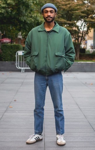 Come indossare e abbinare una giacca harrington verde scuro quando fa caldo in modo casual: Prova ad abbinare una giacca harrington verde scuro con jeans blu per vestirti casual. Sneakers basse in pelle bianche e nere sono una eccellente scelta per completare il look.