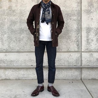 Trend da uomo 2021: Per un outfit quotidiano pieno di carattere e personalità, indossa una giacca leggera marrone scuro con jeans blu scuro. Per le calzature, scegli lo stile classico con un paio di scarpe derby in pelle bordeaux.