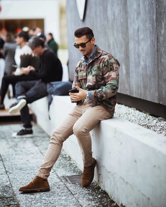 Look alla moda per uomo: Giacca militare mimetica verde oliva, Camicia di jeans blu, Jeans aderenti beige, Stivali eleganti in pelle scamosciata marroni