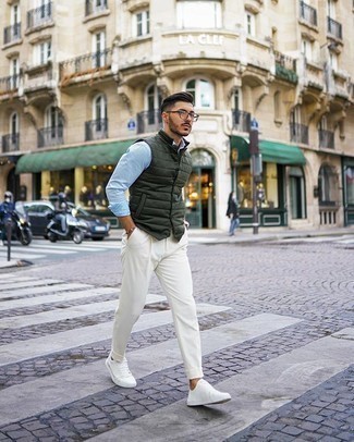 Look alla moda per uomo: Gilet trapuntato verde scuro, Camicia a maniche lunghe azzurra, Chino bianchi, Sneakers basse di tela bianche