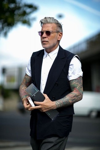 Come indossare e abbinare pantaloni eleganti grigio scuro per un uomo di 50 anni: Combina un gilet nero con pantaloni eleganti grigio scuro per un look elegante e alla moda.
