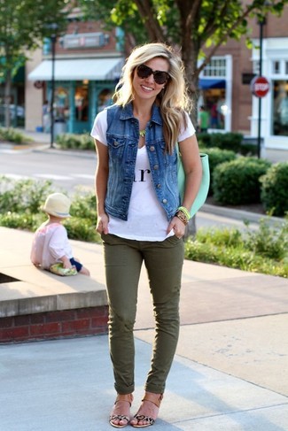 Look alla moda per donna: Gilet di jeans blu, T-shirt con scollo a v stampata bianca e nera, Jeans aderenti verde oliva, Sandali piatti in pelle leopardati beige