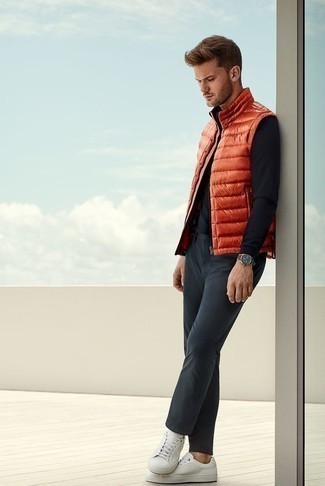 Look alla moda per uomo: Gilet trapuntato arancione, T-shirt manica lunga nera, Chino grigio scuro, Sneakers basse di tela bianche