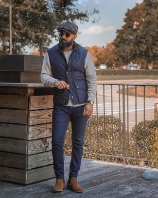 Moda uomo anni 40: Potresti indossare un gilet trapuntato blu scuro e jeans blu scuro per un look raffinato per il tempo libero. Abbellisci questo completo con un paio di stivali chelsea in pelle scamosciata marroni.