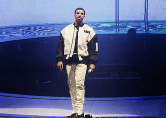 Look di Drake: Giubbotto bomber bianco e nero, T-shirt girocollo stampata nera e bianca, Jeans bianchi, Sneakers alte bianche e nere