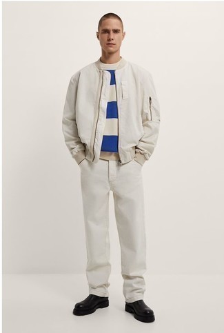 Look alla moda per uomo: Giubbotto bomber bianco, Maglione girocollo a righe orizzontali bianco e blu, Jeans bianchi, Stivali chelsea in pelle neri