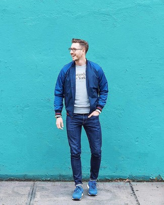 Come indossare e abbinare una felpa stampata grigia con scarpe sportive blu: Indossa una felpa stampata grigia e jeans blu scuro per un look trendy e alla mano. Calza un paio di scarpe sportive blu per avere un aspetto più rilassato.
