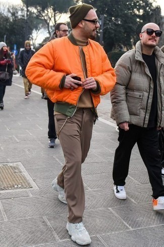 Come indossare e abbinare chino marroni: Potresti indossare un giubbotto bomber arancione e chino marroni per un look semplice, da indossare ogni giorno. Se non vuoi essere troppo formale, mettiti un paio di scarpe sportive bianche.