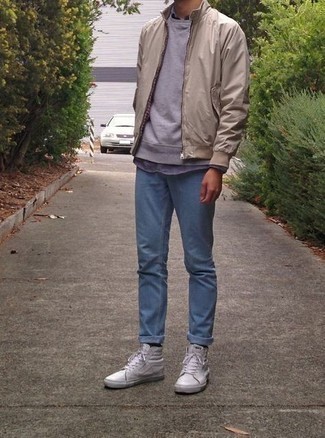 Quale sneakers alte indossare con una felpa grigia per un uomo di 20 anni: Vestiti con una felpa grigia e jeans azzurri per un look semplice, da indossare ogni giorno. Aggiungi un tocco fantasioso indossando un paio di sneakers alte.