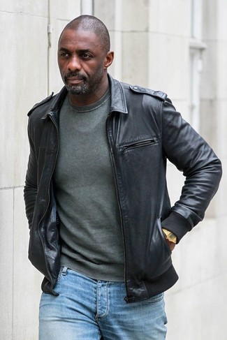 Look di Idris Elba: Giubbotto bomber in pelle nero, Maglione girocollo verde scuro, Jeans azzurri, Orologio dorato